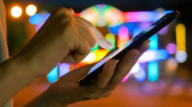 Şehirde akıllı telefon kullanan bir kadın.