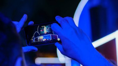 Akıllı telefonlu canlı müzik konserinin görüntülerini kaydeden eller.