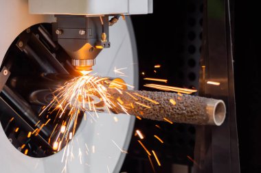 Lazer kesme makinesi, silindirik metal kıvılcımlarla çalışıyor.