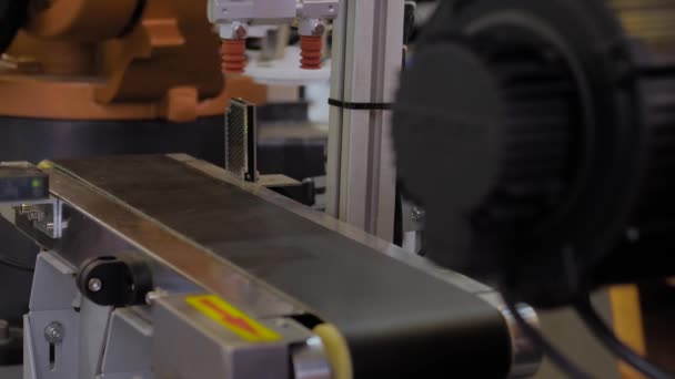 Scegliere e posizionare il braccio robotico che muove il dettaglio in plastica sul nastro trasportatore - da vicino — Video Stock