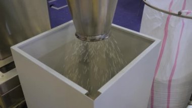 Geri dönüştürülmüş topaklar, fabrikadaki metal konteynırlara düşen plastik granüller.