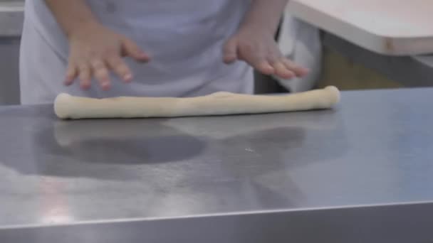 Panadero manos amasando masa fresca en la mesa en la panadería - de cerca — Vídeos de Stock