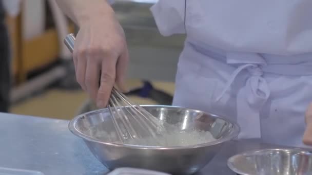 Baker memegang balon kocokan dan menyiapkan krim manis dicambuk — Stok Video
