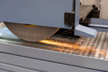 Yüzey öğütücü tekerlek makinesi fabrikada kıvılcımlı levha metalle çalışıyor.