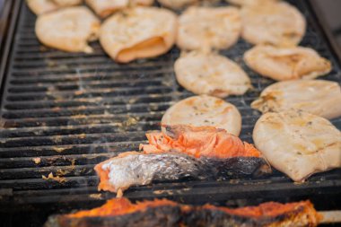Yakın çekim - kalamar pişirme ve ızgarada somon bifteği - sokak yemeği