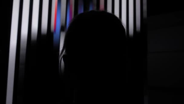 Femme regardant grand écran avec illusion optique rotative dans la pièce sombre — Video