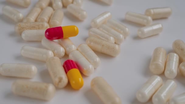 Χάπια, δισκία, φάρμακα, φάρμακα, φάρμακα που περιστρέφονται στη λευκή επιφάνεια - κοντά — Αρχείο Βίντεο