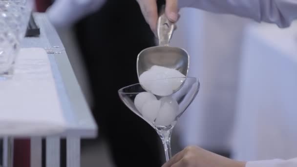 Professional man bartender making alcoholic cocktail - putting ice in glass — Stock Video