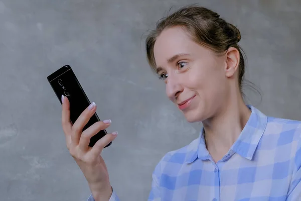 Shocked and surprised woman looking at display of smartphone