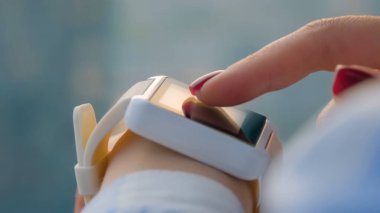 Ofiste takılabilir beyaz akıllı saat kullanan kadın - yan görünümü kapat