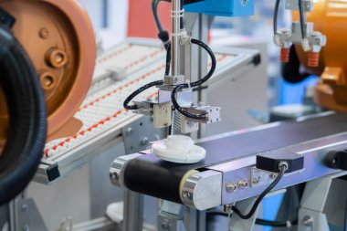 Taşıyıcı bant üzerinde plastik detayı hareket ettiren robotik kol manipülatörü seçin ve yerleştirin