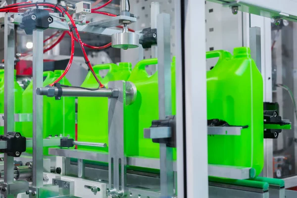 Empty green plastic jerry cans moving on conveyor belt at exhibition — Stock Photo, Image