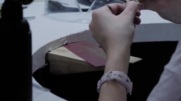 Женщина ювелир, дизайнер полировки ручной работы брошь с наждачной бумагой - крупным планом — стоковое видео