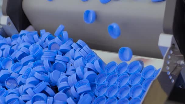 Gerakan lambat: tutup botol plastik biru jatuh dari sabuk konveyor — Stok Video