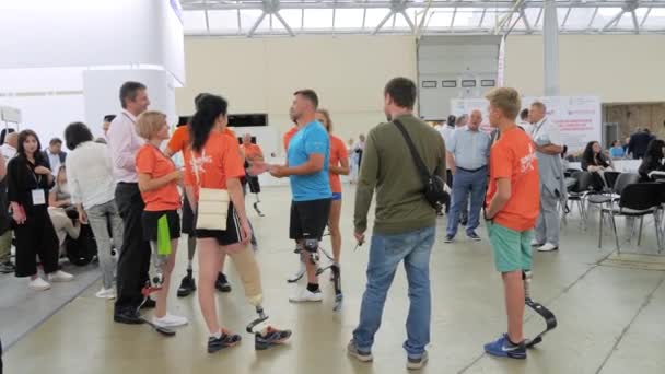 Gruppe behinderter Menschen mit Beinprothese kommuniziert beim Sportwettbewerb — Stockvideo