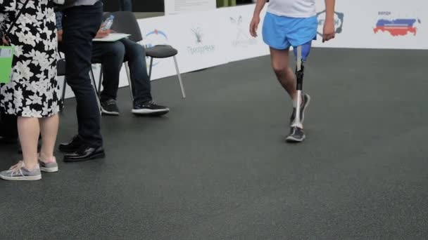 Hombre discapacitado con prótesis de pierna caminando delante del jurado en la competencia — Vídeos de Stock
