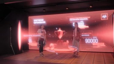 AR sergisindeki karanlık odada 3D büyük hologram projeksiyonuyla poz veren iki kadın.