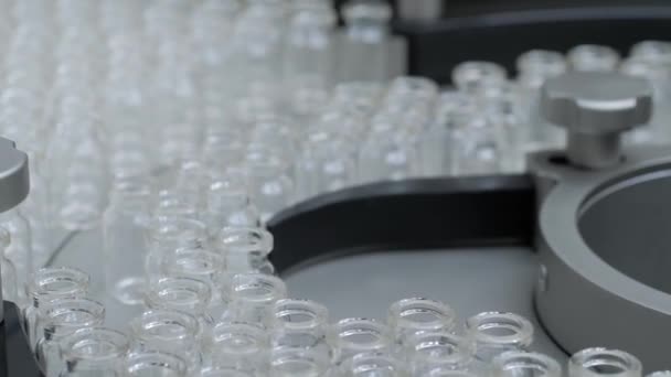 Dopravníkový pás s prázdnými injekčními lahvičkami z lékařského skla - výrobní linka — Stock video