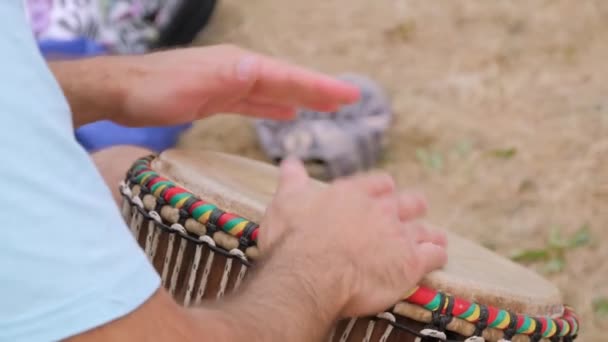 Lassú mozgás: férfi kéz játszik etnikai ütőhangszerek dob djembe: közelről — Stock videók