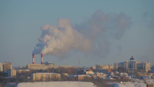 Pohled na budovy města a kouř z továrny smokstack proti modré obloze — Stock video