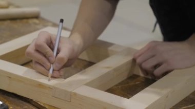 Profesyonel marangoz kalem kullanıyor ve tahta ayrıntı veriyor. Yaklaş.