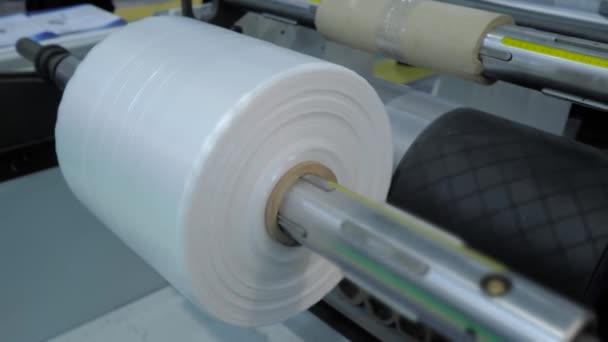 Close up: automatic plastic bag making machine - roller with polyethylene film — Stock Video