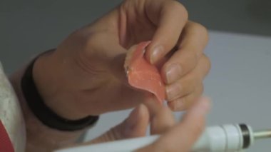 Diş teknisyeni diş protezleriyle çalışıyor. Görüntüyü kapat.