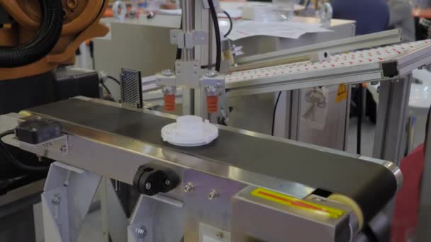 Taşıyıcı bant üzerinde plastik detayı hareket ettiren robotik kol manipülatörü seçin ve yerleştirin — Stok video
