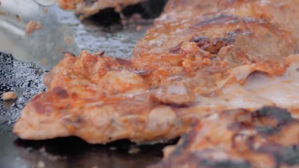 Zeitlupe: Koch mit Zange grillt Fleischsteaks auf Kohlenbecken - Nahaufnahme — Stockvideo