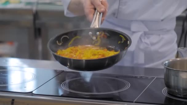 Chef manos cocinar verduras - rodajas de pimiento, cebolla en la sartén — Vídeo de stock