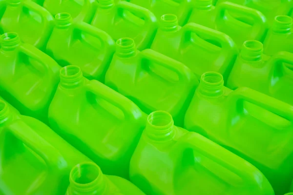 Many empty green plastic jerrycans background - close up