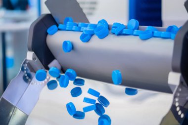 Üretim hattı - birçok mavi plastik şişe kapağı taşıma bandından düşüyor