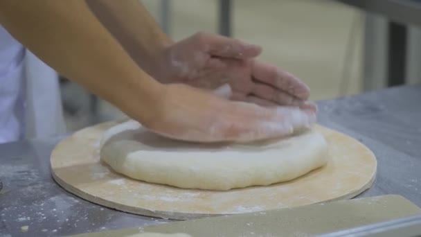 Padeiro mãos amassando a massa de farinha fresca na mesa na padaria - close-up — Vídeo de Stock