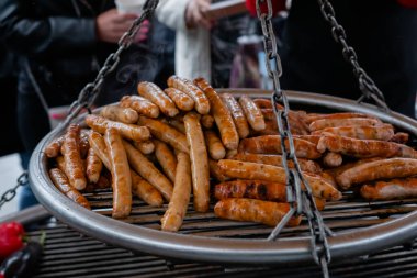 Büyük yuvarlak ızgarada taze et sosisi pişirme işlemi. Kapatın.