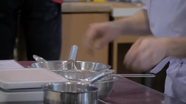 Пекарь просеивает муку через решетку в стальной чаше: закрыть — стоковое видео