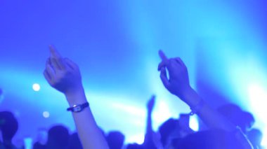 Ağır çekim: genç kız rock konserinde sahnenin önünde parti yapıyor.