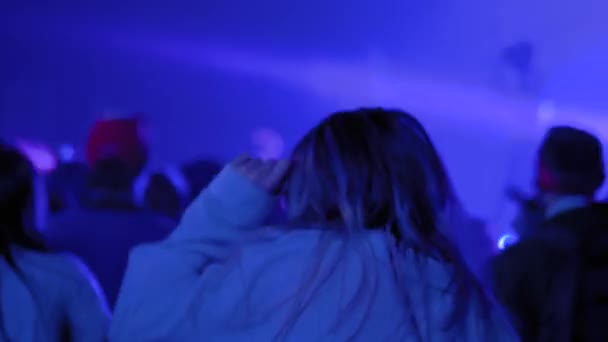Movimento lento: menina adolescente de cabelo longo festejando no concerto de rock em frente ao palco — Vídeo de Stock