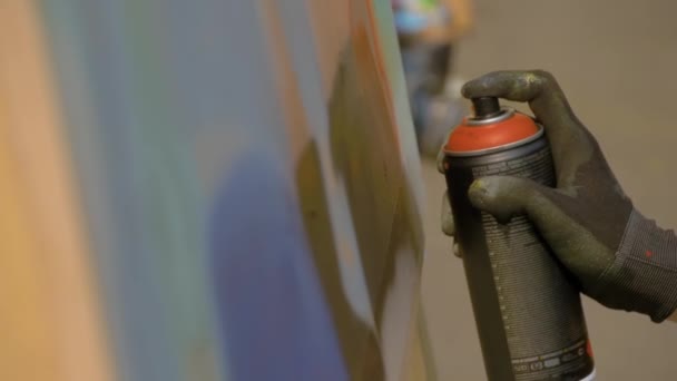 Вуличне мистецтво - людина розпилює фарбу з банки на дерев'яній поверхні на фестивалі графіті — стокове відео