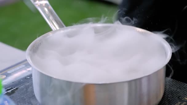 Préparation d'une boisson avec de la glace carbonique dans une casserole à l'exposition scientifique : gros plan — Video