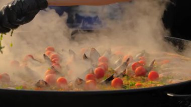 Yavaş çekim: karidesli, midyeli, domatesli paella pişiren şef