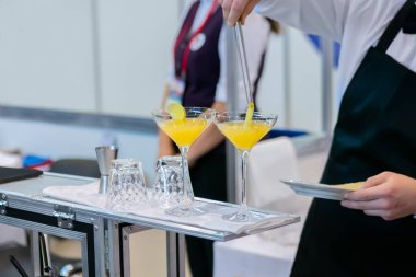 Barmen bar tezgahında alkollü kokteyl yapıyor. Yakın çekim.