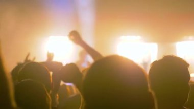 Yavaş çekim: Sahnenin önündeki rock konserinde parti yapan insanların siluetleri