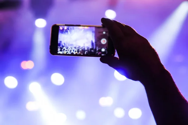 Man hands recording video of live music concert with smartphone