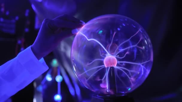Femeia atinge mingea de plasmă cu multe raze de energie în interior - închide — Videoclip de stoc