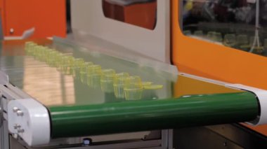 Fabrikada boş plastik bardak taşıyan taşıyıcı bant.