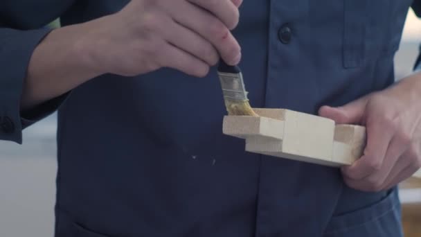 Професійний тесля людина наносить клей на дерев'яні деталі пензлем: крупним планом — стокове відео