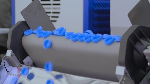 Banyak tutup botol plastik biru yang jatuh dari sabuk konveyor - lini produksi — Stok Video