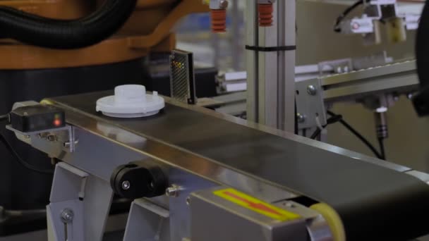 Pick and place robot arm manipulator moving plastic detail on conveyor belt — Stock video