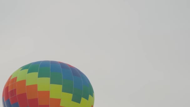 Colorido globo de aire caliente volando contra el cielo gris de invierno — Vídeos de Stock