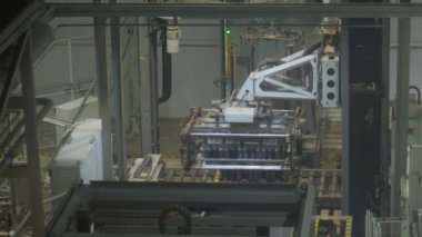 Bira fabrikasında plastik bira şişeleriyle çalışan robotik palletizör.